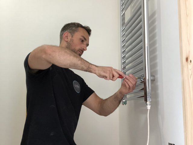 electrician installing an electrical towel rail